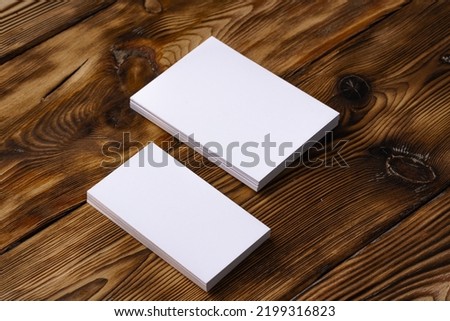 Stack of white business cards on brown wooden background