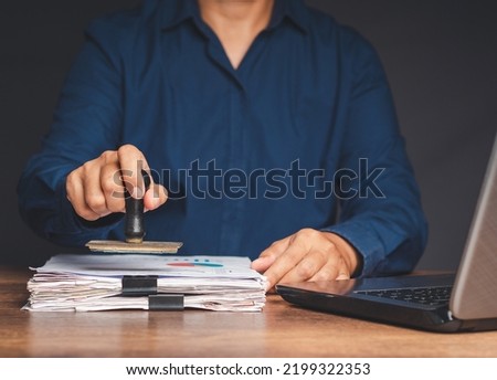 Businessman stamping approved on documents while sitting working in the office. Close-up photo