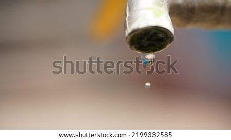 Close-up kitchen faucet, dripping tap water that doesn't close properly, causing wasted water.
