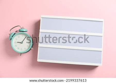 Blank letter board and alarm clock on pink background, flat lay