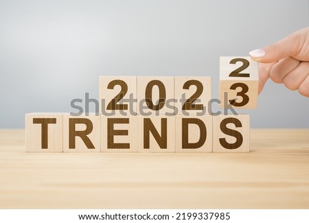 2023 trend concept. Hand flip wooden cube change year 2022 to 2023. gray background, copy space. 2022 trends concept. Hand flip wooden cube change on desk Royalty-Free Stock Photo #2199337985