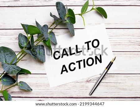 On a light wooden table, there is a eucalyptus branch, a fountain pen and a sheet of paper with the text CALL TO ACTION