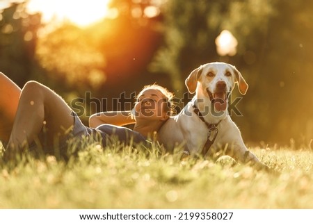 A Woman and her friend dog on the Beautiful sunset background Royalty-Free Stock Photo #2199358027