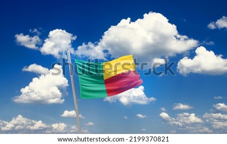 Benin national flag waving in beautiful clouds.