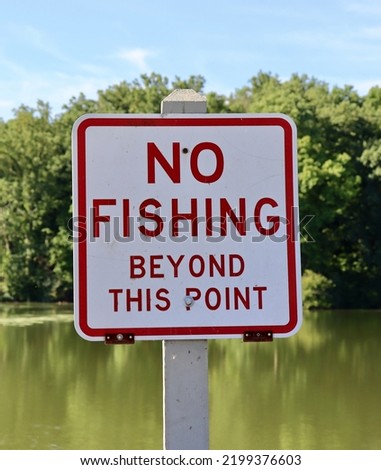 A close view of the red and white no fishing sign.