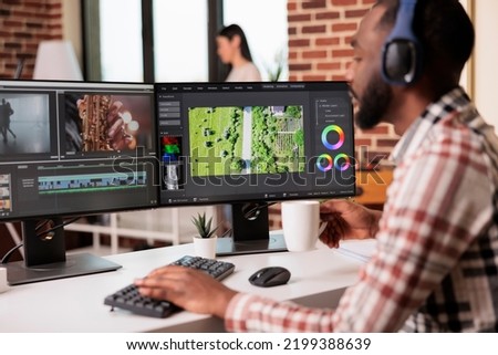 African american videographer editing film montage on professional software computer at home, using visual effects to create multimedia content. Post production footage with sound.
