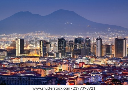 Naples, Italy with the financial district skyline under Mt. Vesuvius at twilight.