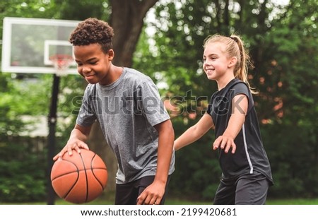 the two teens in sportswear playing basketball game