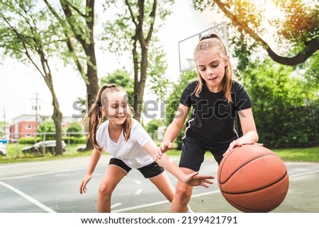 the two girl child in sportswear playing basketball game