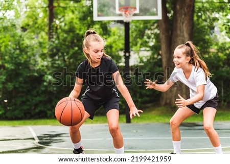 the two girl child in sportswear playing basketball game