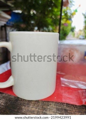 White mug on the table with blurred background. Vintage tone with soft focus. Negative space. Product display template. 