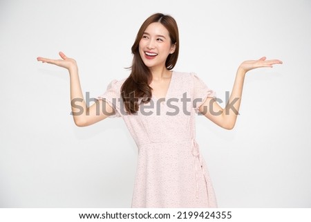 Happy young Asian woman presenting or showing open hand palm with copy space for product isolated on white background Royalty-Free Stock Photo #2199424355