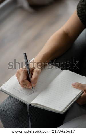 A woman's hand makes notes in a diary, a business woman negotiates, signs important documents in the office