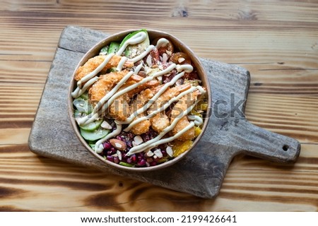 Top down view of tasty torpedo shrimp salad take-away bowl on wooden cutting board Royalty-Free Stock Photo #2199426641
