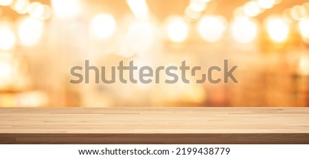 Selective focus.Wood table top (Bar) with blur light bokeh in dark night cafe,restaurant background.Lifestyle and celebration concepts ideas