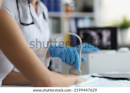 Doctor makes ultrasound of wrist in clinic closeup Royalty-Free Stock Photo #2199447629