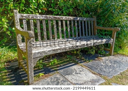 United Kingdom, South West England, Cornwall, Tintagel - The medieval hall-house of 14th century - Rustic wooden garden bench seat in the garden of The Old Post Office. 12th of August, 2022