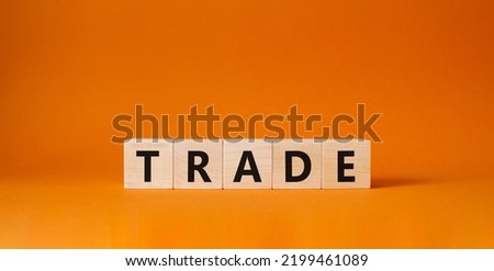 Trade symbol. Wooden cubes with word Trade. Beautiful orange background. Trade concept. Copy space.