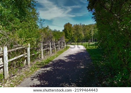 Wooden fence made of round wooden poles along the turn of the road in the park