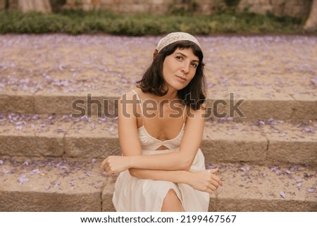 Pretty caucasian young brunette looking at camera relaxing summer in resort town. Woman wears casual clothes. Weekend relaxation concept