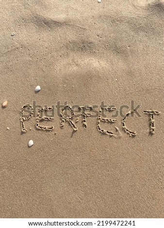 on the beach is carved with letters in the smooth sand the writing Perfect