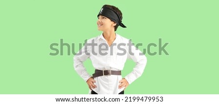 Little boy dressed as pirate on green background