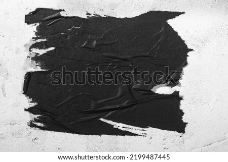 Scraps of black paper on a white wall. Royalty-Free Stock Photo #2199487445