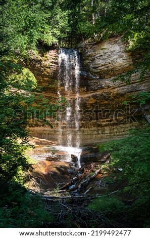 Munising Falls framed by trees in Pictured Rock National Lakeshore on a sunny day
