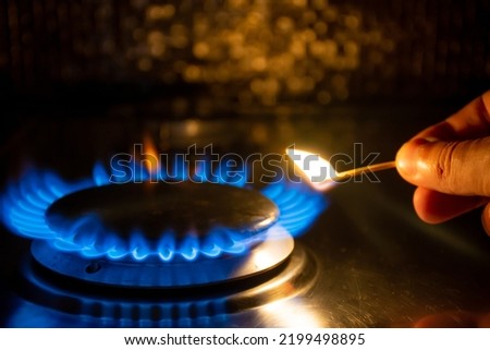 The gas stove is set on fire with a match Royalty-Free Stock Photo #2199498895
