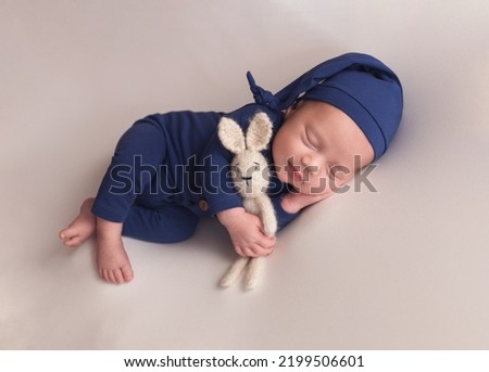 A newborn baby in a blue suit. The first photo session of a newborn. Royalty-Free Stock Photo #2199506601