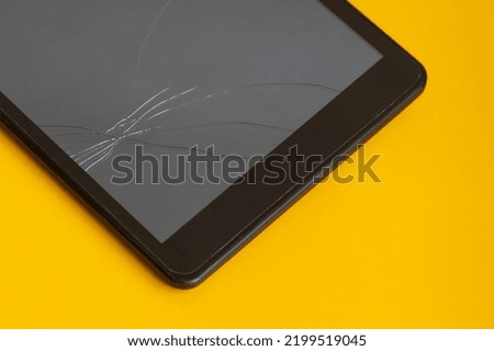 Tablet screen with cracks on yellow background