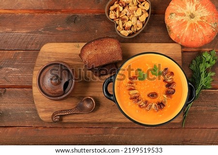 Pumpkin and zucchini cream soup with roasted seeds and toast,traditional autumn vegan food,healthy natural breakfast,advertising for cafe,restaurant,business card,selective focus