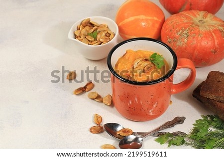 Pumpkin and zucchini cream soup with roasted seeds and toast,traditional autumn vegan food,healthy natural breakfast with place for recipe,advertising for cafe,restaurant,business card,selective focus