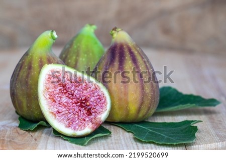 Raw sweet figs on a wooden background closeup. Red - purple e green figs. Figs whole and cut into halves. Organic gardening. High quality photo
