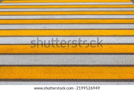 Road marking. Crosswalk, yellow and white lines, close-up. Background. Crosswalk. Pedestrian Crossing Sign .