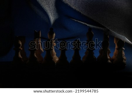 Chess pieces under a black veil without queen and king.