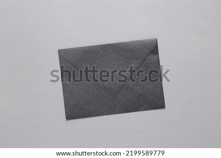 Black envelope with glitter on a gray background