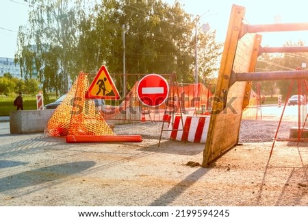 partial closure of the roadway for the period of repair and restoration work, the removed Trench shoring stands nearby, selective focus and backlight Royalty-Free Stock Photo #2199594245