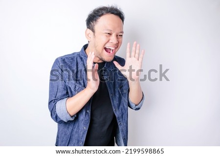 Young beautiful man wearing a blue navy shirt shouting and screaming loud with a hand on his mouth. communication concept.