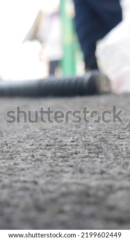 Blur photo of black stick lying on carpet.
