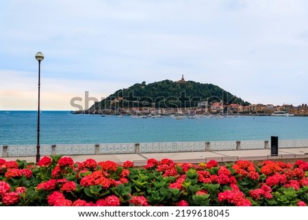 View of La Concha bay and mount Urgull, San Sebastian Donostia at sunset with the city coastline and waterfront homes, Basque Country, Spain
