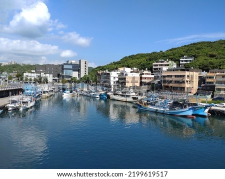 The view of fishing boat parking at the harbor with blue sky in Keelung in Taiwan. The letters and numbers printed on the boat means theirs name.