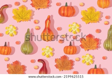 Autumn creative pattern made with pumpkins and leaves and candies  on pastel pink background. Vintage retro aesthetic 80s or 90s fashion concept. Minimal autumn season idea.