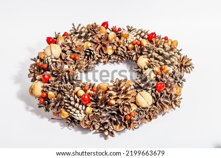 Autumn wreath of cones, nuts, and berries isolated on white background. Creative composition, the handmade. Home decoration festive concept