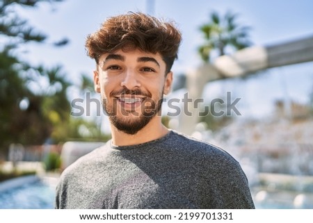 Young arab man smiling happy standing at the city. Royalty-Free Stock Photo #2199701331