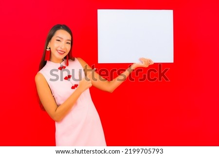 Portrait beautiful young asian woman show white empty billboard on red background