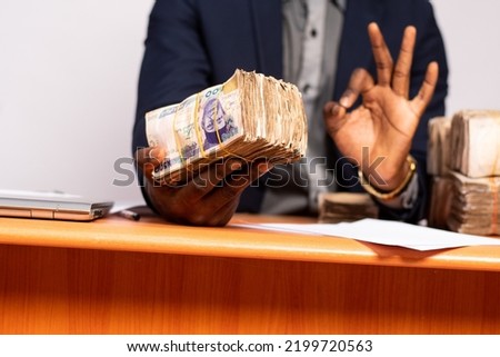 african businessman offering a bundle of cash