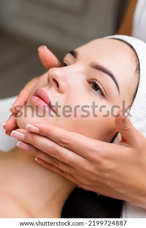 Professional anti-aging facial massage. Action. Relaxing facial treatment at Spa. Relaxing and rejuvenating facial massage for women Royalty-Free Stock Photo #2199724887