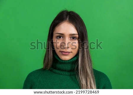 Young beautiful woman or girl model posing in front of green screen background. Portrait of a female with chroma key background.