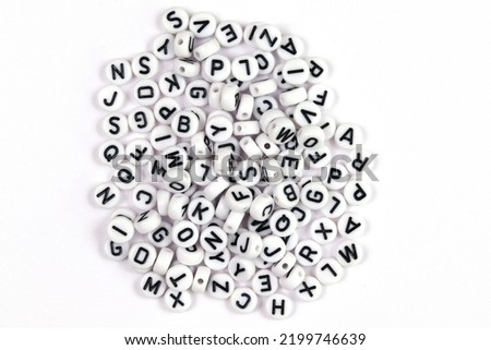 White beads with letters of the English alphabet on a white background. The concept of the development of thinking, grammar.